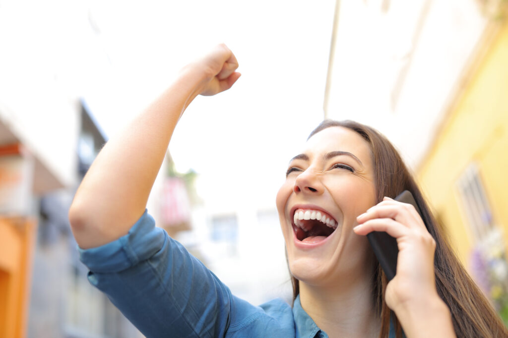 Excited woman receiving good news talking on phone
